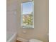 Cozy bathroom featuring a window, and a bathtub with tiled walls at 4634 Mapletree Loop, Wesley Chapel, FL 33544