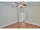 A bright bedroom featuring hardwood floors, a ceiling fan, and white trim, providing a comfortable and stylish space at 4634 Mapletree Loop, Wesley Chapel, FL 33544