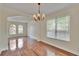 Bright dining room featuring hardwood floors, a chandelier, and large window at 4634 Mapletree Loop, Wesley Chapel, FL 33544