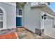 Charming entryway with a blue front door, stone accents, and decorative tile walkway at 4634 Mapletree Loop, Wesley Chapel, FL 33544