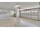 Spacious garage with concrete flooring, a large overhead door, and ample room for parking and storage at 4634 Mapletree Loop, Wesley Chapel, FL 33544