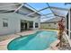 Relaxing screened-in pool with an adjoining patio and serene backyard at 4634 Mapletree Loop, Wesley Chapel, FL 33544