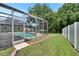 Inviting screened-in pool surrounded by well-maintained landscaping and a privacy fence at 4634 Mapletree Loop, Wesley Chapel, FL 33544