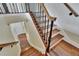 Staircase with wooden stairs, decorative iron railings, and white risers at 4634 Mapletree Loop, Wesley Chapel, FL 33544