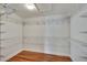 Walk-in closet with built-in shelving and hardwood floors at 4634 Mapletree Loop, Wesley Chapel, FL 33544