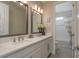Bright bathroom featuring double sinks, quartz counters, and a shower/tub combo with tile surround at 4644 San Martino Dr, Wesley Chapel, FL 33543