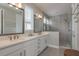 Stylish bathroom with dual sinks, walk-in shower with rain shower head and tile surround at 4644 San Martino Dr, Wesley Chapel, FL 33543