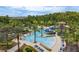 Resort-style community pool featuring multiple slides, lush landscaping, and comfortable lounge areas at 4644 San Martino Dr, Wesley Chapel, FL 33543