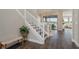 Inviting entryway features a staircase with white railings, wood-look tile flooring, and a dining area with lake views at 4644 San Martino Dr, Wesley Chapel, FL 33543