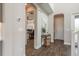 Inviting hallway with arched doorways, stylish flooring, and a glimpse into a bright office space at 4644 San Martino Dr, Wesley Chapel, FL 33543