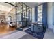 Open-concept living space with hardwood floors, stylish furniture, and a glass-walled room at 4644 San Martino Dr, Wesley Chapel, FL 33543