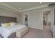 Relaxing main bedroom with a tufted headboard, tray ceiling and neutral tones at 4644 San Martino Dr, Wesley Chapel, FL 33543