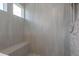 This gorgeous walk-in shower features gray tile and a built-in bench at 4644 San Martino Dr, Wesley Chapel, FL 33543