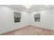 Bright bedroom featuring wood flooring, two windows with gray Roman shades, and neutral paint at 4708 W Neptune St, Tampa, FL 33629