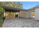 Open carport attached to the house with brick-paved driveway at 4708 W Neptune St, Tampa, FL 33629