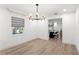 Bright dining room with modern light fixture, window, and view to kitchen at 4708 W Neptune St, Tampa, FL 33629