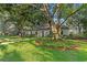 Well-manicured front lawn with mature trees and quaint landscaping at 4708 W Neptune St, Tampa, FL 33629