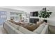 Bright living room with a large white sectional couch, light wood floors, and a large tv at 4708 W Neptune St, Tampa, FL 33629