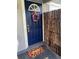 Beautiful blue front door with a decorative wreath and strawberry welcome mat at 4721 W Wallace Ave, Tampa, FL 33611