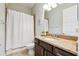 Neutral bathroom featuring granite counters, framed mirror, and bathtub with shower featuring white shower curtain at 6007 Quartz Lake Way, Lithia, FL 33547