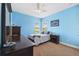 This cozy bedroom features blue walls, carpeted floors, a ceiling fan, and natural light from dual windows at 6007 Quartz Lake Way, Lithia, FL 33547