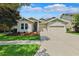 Well-maintained single-story home with a two-car garage, set against a backdrop of blue sky and clouds at 6007 Quartz Lake Way, Lithia, FL 33547
