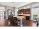 Modern kitchen with granite countertops, dark wood cabinetry, and an expansive island with seating at 6007 Quartz Lake Way, Lithia, FL 33547