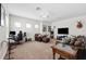 Spacious living room with neutral carpet and walls, ceiling fan, leather couches, and a television viewing area at 6007 Quartz Lake Way, Lithia, FL 33547