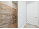 Walk-in shower featuring tile walls and flooring next to a white paneled door at 6007 Quartz Lake Way, Lithia, FL 33547