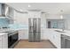 Bright kitchen with stainless steel appliances, white cabinetry, and modern backsplash at 605 Bosphorous Ave, Tampa, FL 33606