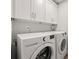 Bright laundry room featuring a modern washer and dryer and white cabinetry for additional storage space at 605 Bosphorous Ave, Tampa, FL 33606