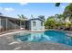 The backyard features a private pool with brick pavers, complemented by the home's cheerful blue exterior and sunny skies at 605 Bosphorous Ave, Tampa, FL 33606