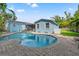 Aerial view of a sparkling pool with brick pavers, a blue home exterior, and a screened-in porch in a private backyard at 605 Bosphorous Ave, Tampa, FL 33606