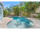 The backyard showcases a pristine pool with lush tropical landscaping, a brick paver deck, and ample space for relaxation at 605 Bosphorous Ave, Tampa, FL 33606