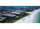 Breathtaking aerial view of beachfront condos with pools, lush landscaping, and direct access to the sandy beach and ocean at 6600 Sunset Way # 118, St Pete Beach, FL 33706