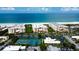 Stunning aerial view showcasing beach condos, tennis courts, and the beautiful ocean at 6600 Sunset Way # 118, St Pete Beach, FL 33706