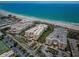 Stunning aerial view of beachfront condo complex with pristine white sands and turquoise ocean waters at 6600 Sunset Way # 118, St Pete Beach, FL 33706