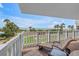 Relaxing lounge chairs on a balcony with views of the beach and palm trees at 6600 Sunset Way # 118, St Pete Beach, FL 33706