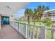 Inviting balcony with views of manicured grounds, mature palm trees, and a neighboring building in a coastal community at 6600 Sunset Way # 118, St Pete Beach, FL 33706