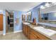 Spacious bathroom features dual sinks, wood cabinets, and a tiled walk-in shower at 6600 Sunset Way # 118, St Pete Beach, FL 33706