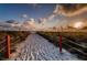 Scenic beach access with rope fencing leading to a sandy shore and ocean at 6600 Sunset Way # 118, St Pete Beach, FL 33706