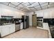 Traditional kitchen features white cabinets, black countertops, and stainless steel appliances at 6600 Sunset Way # 118, St Pete Beach, FL 33706