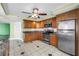 Well-equipped kitchen features wood cabinetry, stainless steel appliances, and tiled flooring at 6600 Sunset Way # 118, St Pete Beach, FL 33706