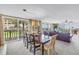 Bright, open living area features floor-to-ceiling sliding glass doors, dining table, and comfortable seating at 6600 Sunset Way # 118, St Pete Beach, FL 33706