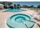 Community pool area featuring a hot tub and sun loungers for residents' relaxation at 6600 Sunset Way # 118, St Pete Beach, FL 33706