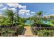 Tennis courts are surrounded by lush landscaping and mature palm trees and are accessed by a concrete walking path at 6600 Sunset Way # 118, St Pete Beach, FL 33706