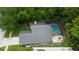 An aerial view showcasing the home's screened pool and backyard with a cozy fire pit at 7320 Hideaway Trl, New Port Richey, FL 34655
