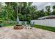 Charming backyard patio with a stone fire pit and comfortable Adirondack seating at 7320 Hideaway Trl, New Port Richey, FL 34655