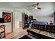 Bright bedroom features a ceiling fan, an open closet space, and a futon for additional seating at 7320 Hideaway Trl, New Port Richey, FL 34655