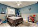 Cozy bedroom with blue and gray walls, neutral carpet, ceiling fan and playful decor at 7320 Hideaway Trl, New Port Richey, FL 34655